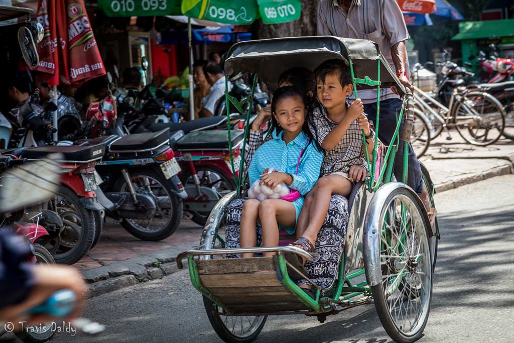 While on a Cyclo Tour of Phnom Penh, this family savored the identical mode of transportation. Photo credit: Travis Daldy.